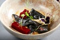 Mussels in black in beige bowl