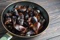 Mussels with parsley and garlic in wog pan on wooden table