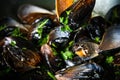 Mussels with parsley and garlic in wog pan on wooden table