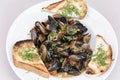 Mussels in sauce with parsley,  French toast and lemon. Seafood. Clams in the shells. Delicious snack for gourmands. Isolated on Royalty Free Stock Photo