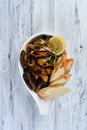 mussels in a shell with sauce, croutons, lemon and sprouts in a white plate