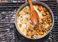 Mussels simmer in a creamy sauce over an open fire.