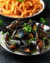 Mussels with white wine, garlic, lemon and herbs in a plate, French fries. rustick background. Seafood Royalty Free Stock Photo