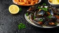 Mussels with white wine, garlic, lemon and herbs in a plate, French fries. rustick background. Seafood Royalty Free Stock Photo