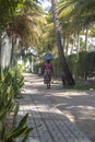 View of pedestrian path, with woman selling street walking and also a man, in Mussulo island