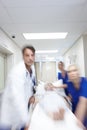 We must act quickly. A group of doctors rushing a patient down the corridor. Royalty Free Stock Photo