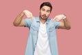 Must be here and right now. Portrait of serious handsome bearded young man in blue casual style shirt standing, pointing down and