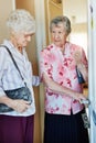 We must make sure its locked. two elderly woman closing the door before they leave to go out.