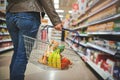 Must stock up. a woman holding a basket while shopping at a grocery store. Royalty Free Stock Photo