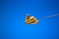 Mustard paste on a small silver spoon Close up studio shot, isolated on blue background Royalty Free Stock Photo