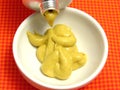 Mustard pressed out of a mustard tube