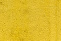 Mustard rough concrete surface, seamless uneven abstract wallpaper. Yellow wal Royalty Free Stock Photo