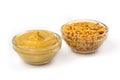 Mustard yellow sauce in a clear bowl and Pickled mustard seeds isolated on a white background Royalty Free Stock Photo