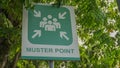 Muster Point signboard with green tree leaves background