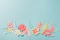 Muted color colorful flower composition - handmade papercraft flowers and leaves on pastel blue background, sprin, summer, easter