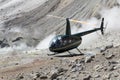 Touristic Helicopter in crater of active volcano on background of smoking fumaroles