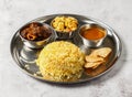 Mutton biryani thali set with korma karahi, mixed vegetable of aloo gobi matar, nachos and shorba served in dish isolated on