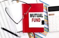 MUTUAL FUND text on notebook with chart, calculator and pen