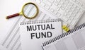 MUTUAL FUND text written on notebook on chart with keyboard and planning