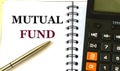 MUTUAL FUND word in a notebook against the background of calculitar