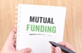 Mutual funding word on white ring binder notebook with hand hold