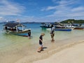 Indonesian people with White sand beach, mountains, boat, ship, clouds and sky