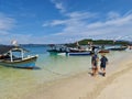 Indonesian people with White sand beach, mountains, boat, ship, clouds and sky