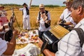 Accordionist stretches bellow of harmonic, music for good harvest