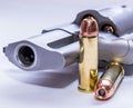 The muzzle of a 454 casull snub nose revolver loaded with hollow point bullets and two additional ones next to it