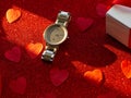 Gift box and silver watch is on red heart paper background