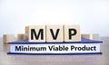 MVP, minimum viable product symbol. Wooden cubes on book with words MVP, minimum viable product. Beautiful white background. Royalty Free Stock Photo