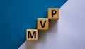 MVP, minimum viable product symbol. Wooden cubes with the word MVP, minimum viable product. Beautiful white and blue background. Royalty Free Stock Photo