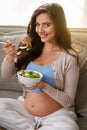 My baby loves it when I eat organic food. a pregnant woman eating a healthy salad at home. Royalty Free Stock Photo