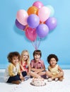 My birthday wish is to be friends forever. Shot of a group of children sitting around a birthday cake with bunch of Royalty Free Stock Photo