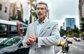 My cab should arrive any time now. a mature businessman checking the time on his wrist watch out in the city. Royalty Free Stock Photo