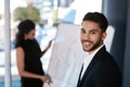 My colleague does a great job. Cropped portrait of a handsome young businessman standing while his colleague prepares a