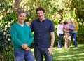 My Dad, my best friend. Portrait of a young man standing with his father with the rest of the family in the background. Royalty Free Stock Photo