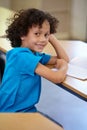 This is my favorite class. Portrait of a cute ethnic boy sitting in his classroom.