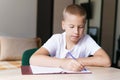 My favorite subject. Handsome smiling blonde boy is working and writing in his Royalty Free Stock Photo