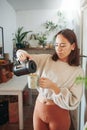 My favourite part of the day is coffee. a young woman pouring herself a cup of coffee. Royalty Free Stock Photo