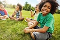 My friends are the coolest to hangout with. Portrait of a young boy sitting together with his friends on the grass