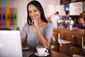 My friends send the funniest emails. A happy woman using her laptop at a coffee shop. Royalty Free Stock Photo