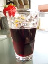 My glass of red wine coctail with strawberry decoration on table