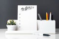 My goals list on notepad at modern office stationery on white table and dark grey wall.pencil, notepad,ruler,pen and pencil box Royalty Free Stock Photo