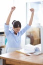 My hard work paid off. A young businesswoman celebrating a victory while sitting at her office desk. Royalty Free Stock Photo