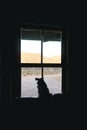 When are my humans coming home. Rearview shot of an adorable dog looking out of a window at home. Royalty Free Stock Photo