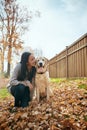 My labbie, my love. an attractive young woman having fun with her dog on an autumn day in a garden.