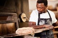 My love for baking is why I started this business. a male baker removing freshly baked bread from the oven.