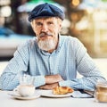 My love of coffee has kept me young. Portrait of a happy senior man enjoying a cup of coffee at a sidewalk cafe. Royalty Free Stock Photo