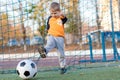 A little boy plays soccer in a city Park gives a pass kicks a ball Royalty Free Stock Photo